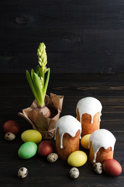 Foto dolce e uova di pasqua di natura morta di pasqua su un fondo scuro e di legno.