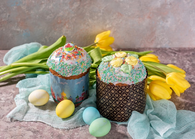 Easter still life. Easter cake, painted eggs with tulips on a wooden old rustic background.