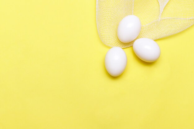 Easter surface white chicken eggs on a yellow surface