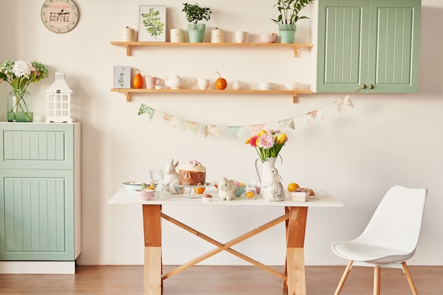 Easter sweet bread, Easter cake and multi-colored eggs with tulips and a white rabbit. Holidays breakfast concept with copy space.