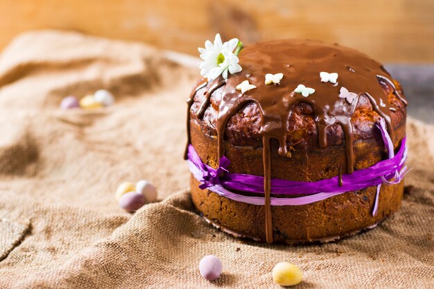 Easter sweet bread orthodox kulich, paska, willow twigs. easter\
colorful eggs on wooden background.