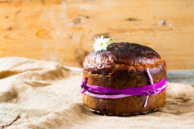 Easter sweet bread orthodox kulich, paska, willow twigs. easter
colorful eggs on wooden background.