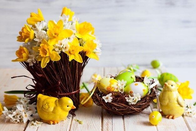 Easter table decoration with fresh daffodilschick and eggs