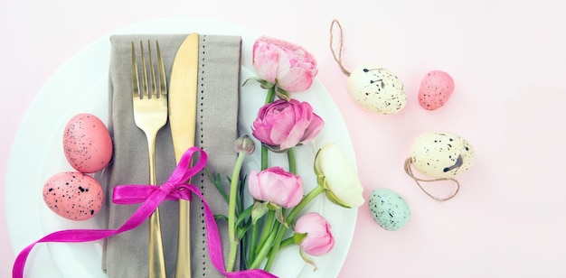 Easter table setting Easter eggs and flowers decoration napkin and golden cutlery