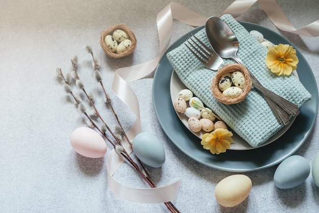 Photo easter table setting ideas, minimal decoration - easter eggs, willow catkin branches, bird's nest