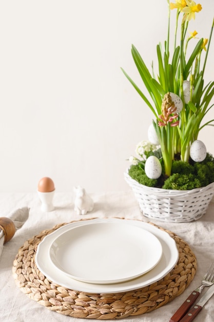 Easter table setting with blue coloful eggs festive decorations fresh flowers