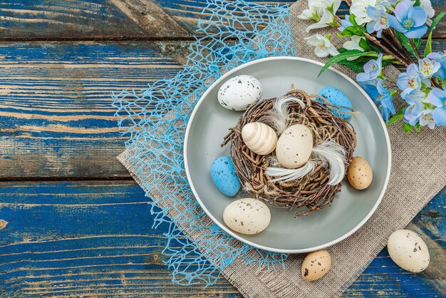 Easter table setting with eggs bird39s nest and blooming branch