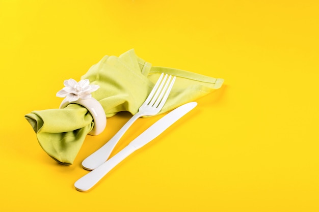 Regolazione della tabella di pasqua con cucina posate su uno sfondo giallo brillante