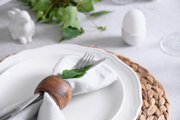 Easter table setting with white bunny and eggs fresh flowers close up