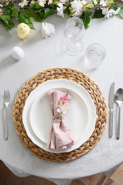 Easter table setting with yellow chick fresh flowers and eggs close up