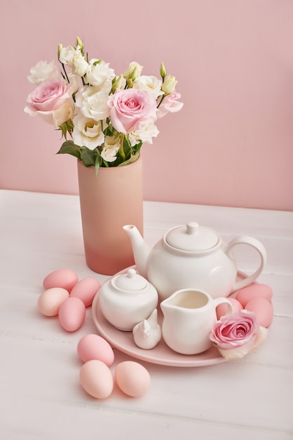 Easter tea-set and colorful eggs on festive table.