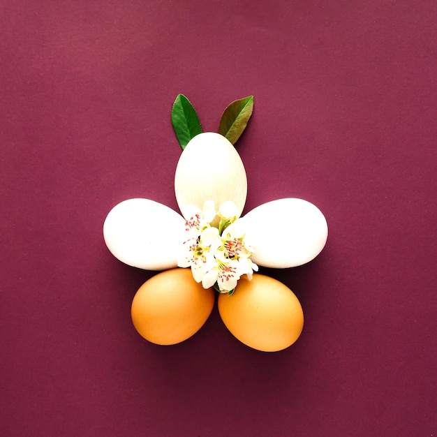 보라색 배경에 중간에 흰색 아름다운 봄 꽃과 부활절 흰색 달걀