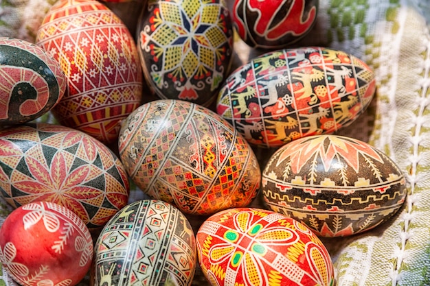 Easter wooden eggs into national old russian patterns on a\
plate with a kitchen towel