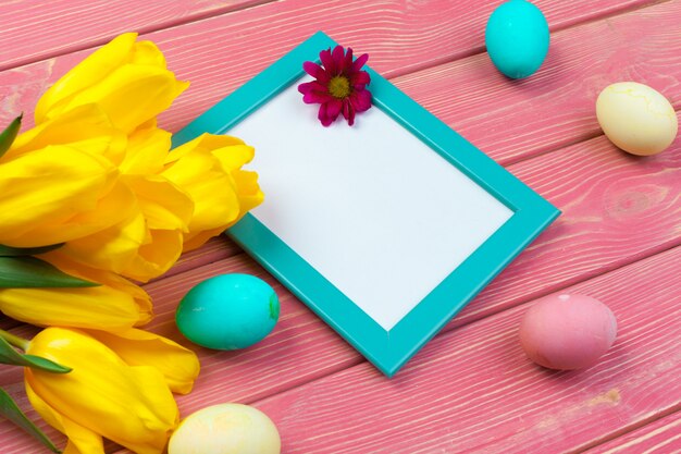 Easter . wooden frame with easter eggs and tulips on colorful