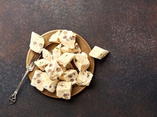 Eastern delicacy. Halva, sweetness, dessert on brown background.