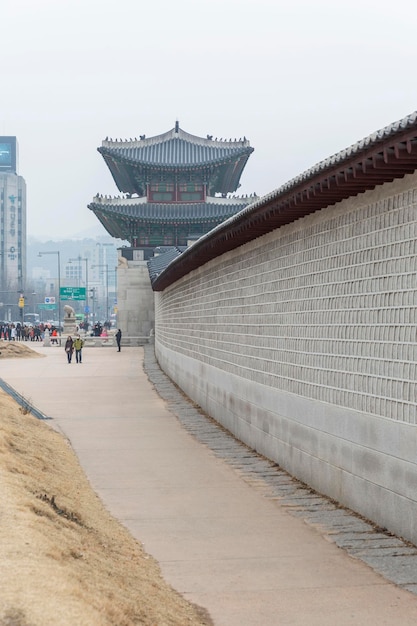 사진 서울 한가운데 있는 동탑과 고층 빌딩 국립공원 입구의 긴 돌담 종교와 건축 클로즈업 수직