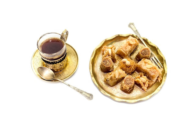Восточные сладости пахлавадакия и чашка кофе на белом фоне