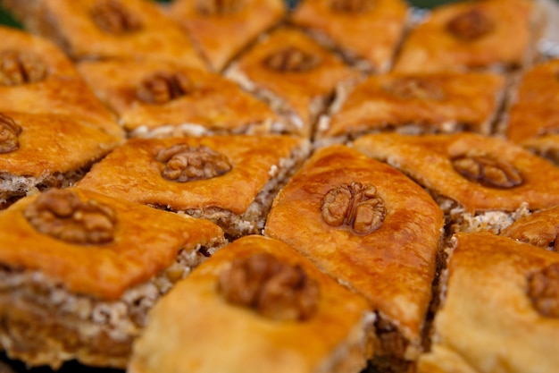 Восточные сладости - пахлава десертная, сверху украшенная грецкими орехами, крупным планом