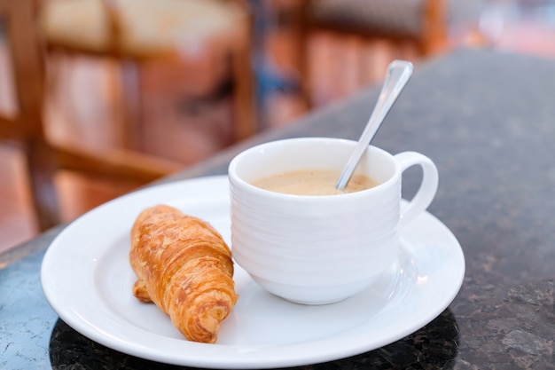 写真 クロワッサンとホットコーヒーで朝の簡単な朝食。