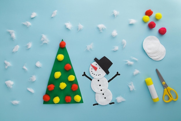 Easy craft for kid winter greeting card christmas tree and
snowman from paper pom pon and cotton disc children's art project
diy concept