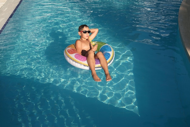 Easy living amidst the heat a young adventurer transforms a pool float into his personal oasis