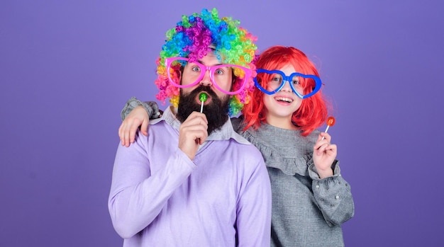 Easy simple ways be fun playful parent Man bearded father and girl wear colorful wig while eat lollipop candy Thing loving father do for children Tribute to fun dad How crazy is your father