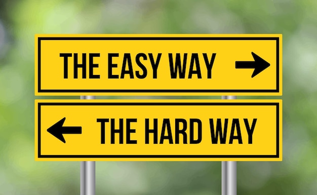 The easy way or the hard way road sign on blur background