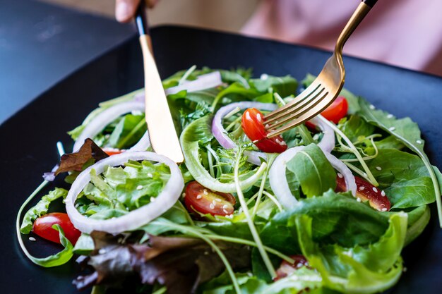 Foto mangi il concetto verde con l'insalata organica della verdura fresca in piatto ceramico.