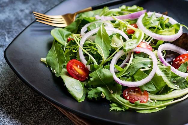 Eat green concept with organic fresh vegetable salad in ceramic plate.