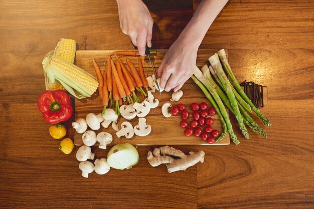 Eat green eat clean high angle shot of a woman cutting a variety of healthy vegetables on a chopping board