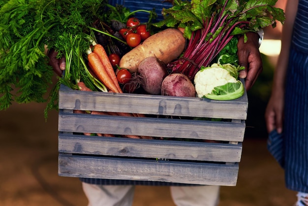 Ешьте здоровую пищу, оставайтесь здоровыми Обрезанный снимок неузнаваемого фермера, держащего ящик со свежими продуктами на своей ферме