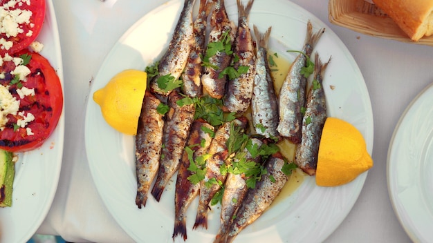 Eating appetizing sardines dish served with parsley and lemon