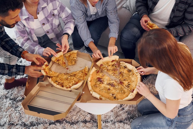 Eating delicious pizza Group of friends have party indoors together
