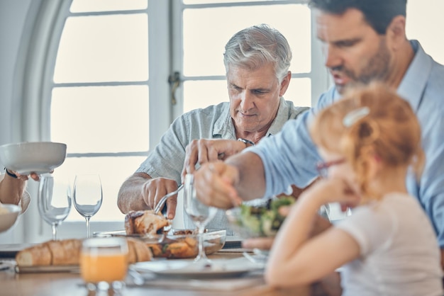 Eating dining room and senior man with his family enjoying a meal together in their modern house Father girl child and grandfather in retirement having food at celebration dinner lunch or event