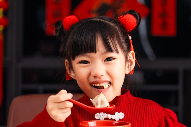 中国の祭りでダンプリングを食べる 女の子は家でダンプングを食べる