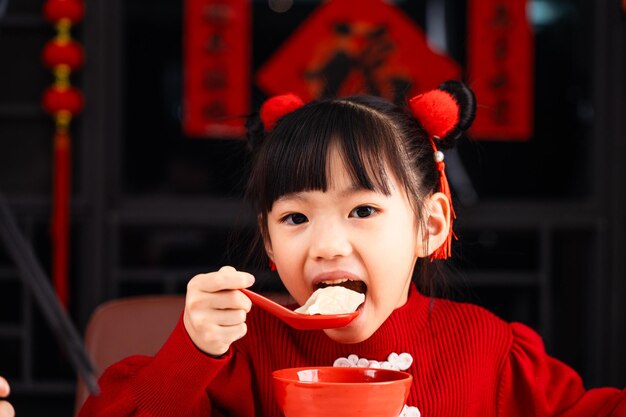 Photo eating dumplings during chinese festival girls eat dumplings at home