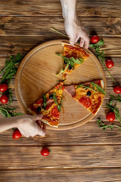 Eating Food. Close-up Of People Hands Taking Slices Of Pepperoni Pizza.