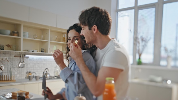 Eating happy couple cooking breakfast in kitchen close up romantic lunch home