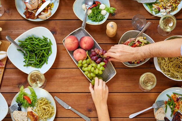 Foto concetto di cibo e svago gruppo di persone che cenano a tavola con cibo