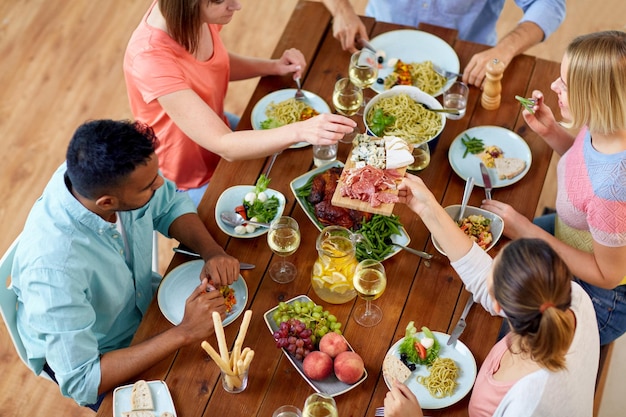 Photo eating and leisure concept group of people having dinner at table with food