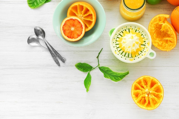 Eating oranges with spoon on white wooden background