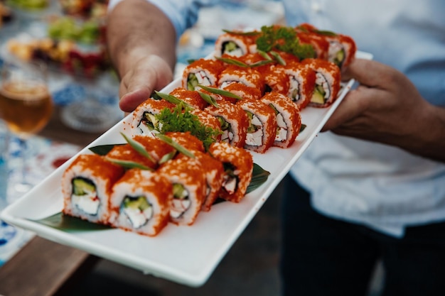 Eating sushi with chopsticks close up food takeout and delivery\
service salmon sushi rolls tasty meal sushi delivery