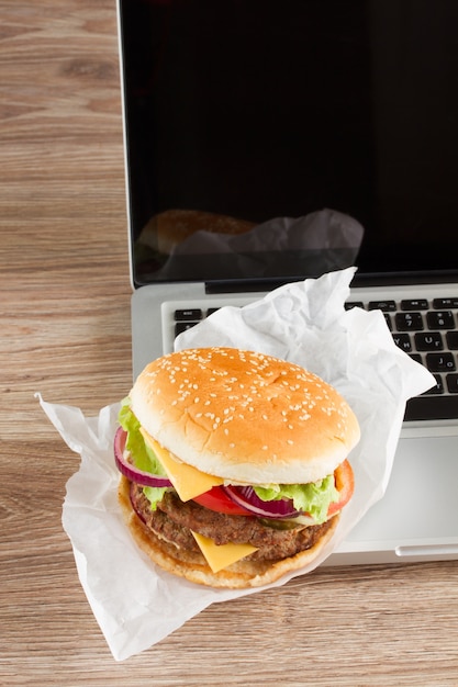 Eating at work place fast food near laptop concept