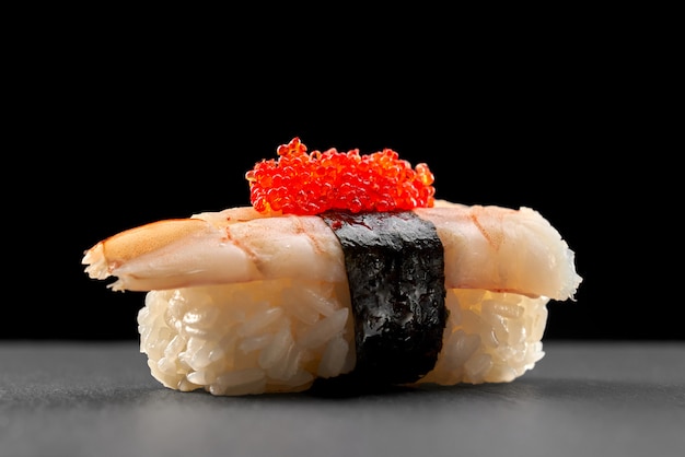 Ebi nigiri topped with red flying fish roe.