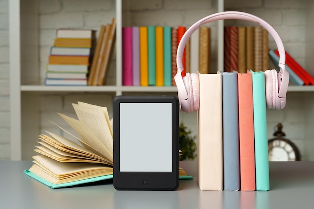 Ebook reader on table against book shelves