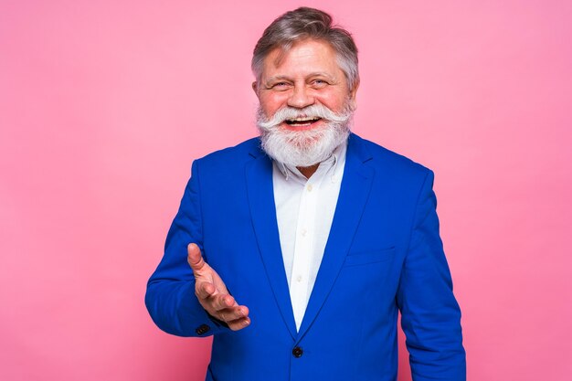 Eccentric senior man with funny expression on pink wall