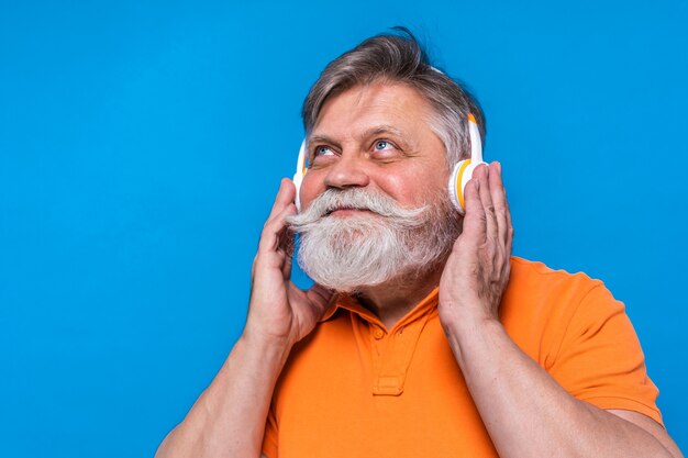 Eccentric senior man with funny expression portrait isolated on blue