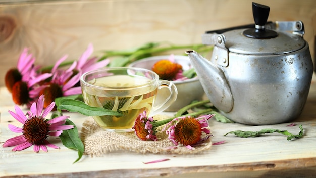 Echinacea flowers and echinacea drink on a wooden surface