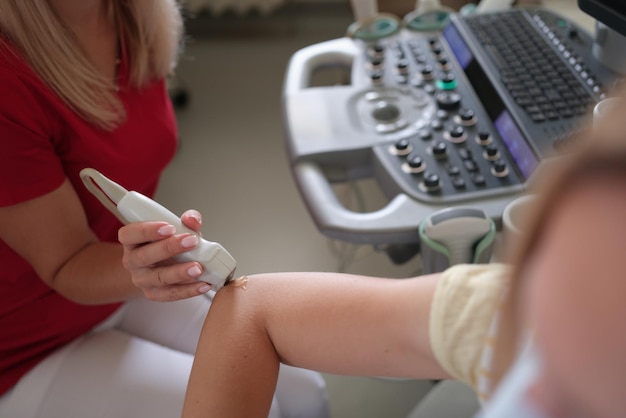 Echografie van de elleboog van de handen in het botprobleem van de dokterskliniek en het concept van artritis