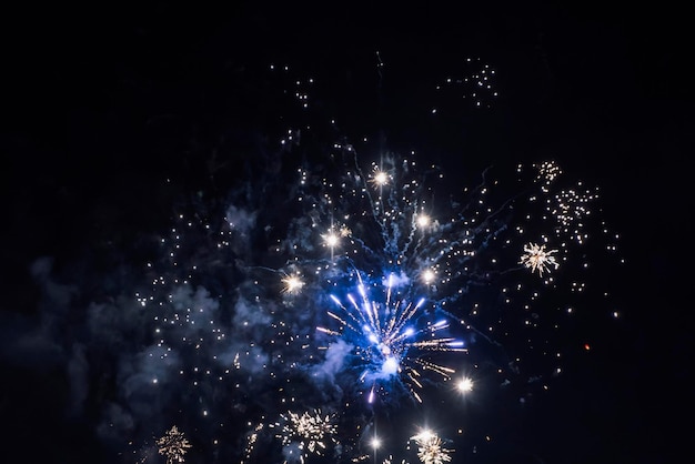 Echt vuurwerk tegen de zwarte lucht 's nachts. Pyrotechniek explodeert, het nieuwe jaar vieren